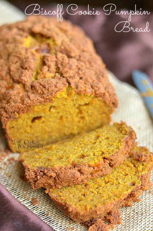 A couple slices of Biscoff Cookie Pumpkin Bread have been cut. The inside of this bread is orange-ish in color. It is heavily topped with streusel.