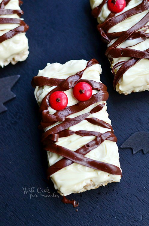 halloween decorated double chocolate rice krispie treats as mummies on black table