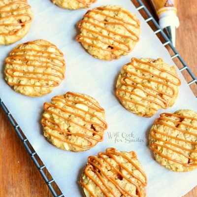 several dulce de leche apple caramel oatmeal cookies on cooling rack with wax paper on wood table