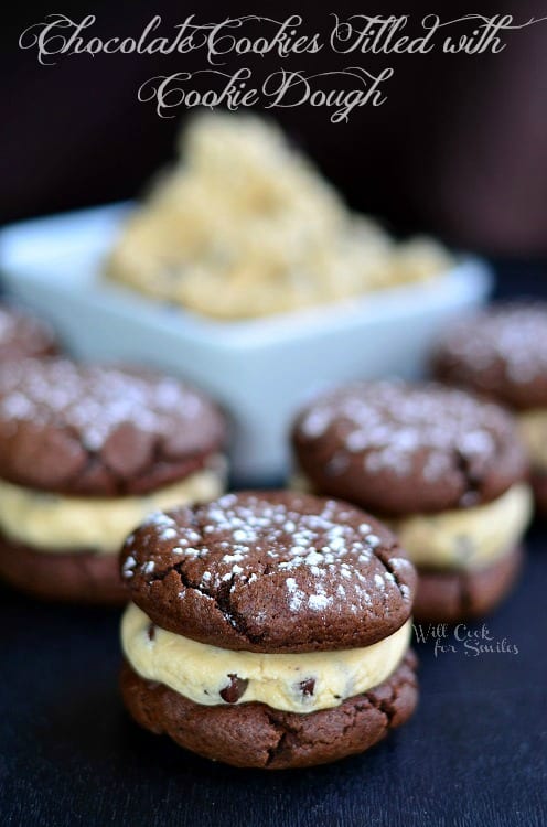 close up of chocolate cookie sandwich with Cookie Dough Filling stacked up on a table 