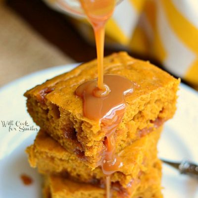 syrup bottle pouring syrup on stack of 3 pumpkin caramel blondies