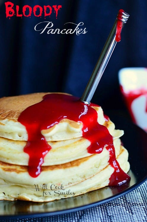Bloody Pancakes- pancakes with red syrup stacked up on a plate 