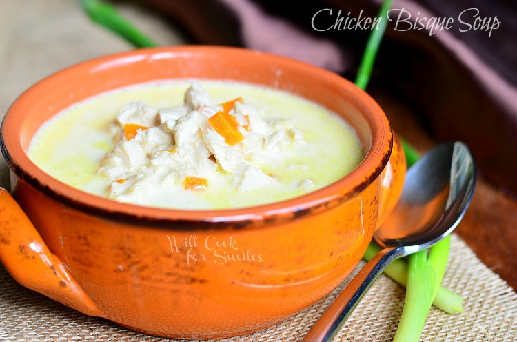  Chicken Bisque Soup in an orange bowl with a spoon to the right 