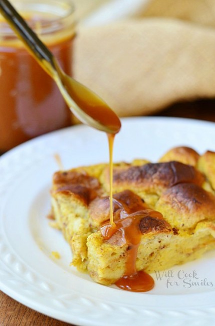 Pumpkin Bread Pudding with Homemade Caramel being drizzled over it on a white plate 