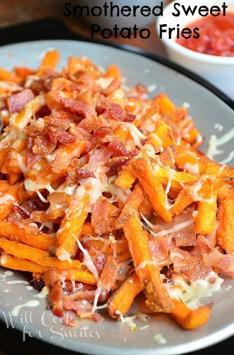 sweet potato fries with bacon and cheese on top on a grey plate 