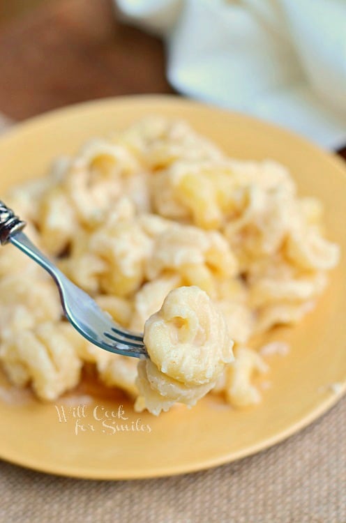 White Mac and Cheese on a yellow plate with a some on fork