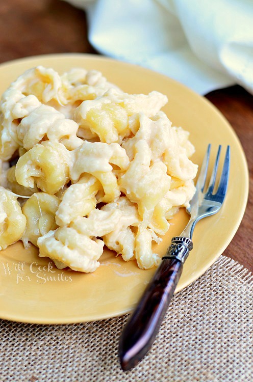 White Mac and Cheese on a yellow plate with a fork to the right 