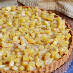 above view of apple pie custard tart with cake cutter at bottom right