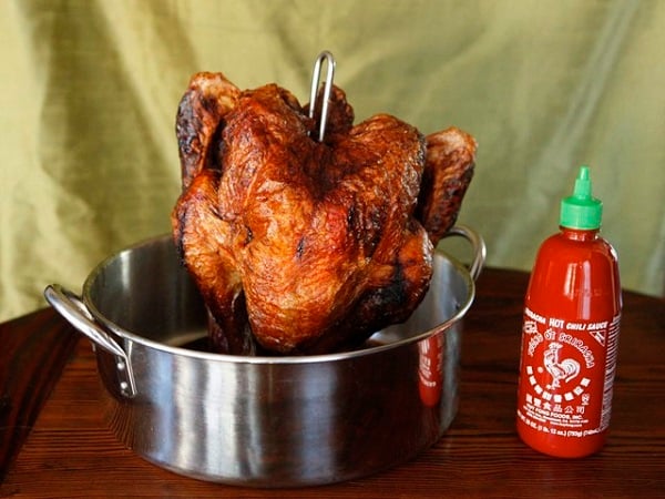 turkey in a pot with a bottle of sriracha next to it 