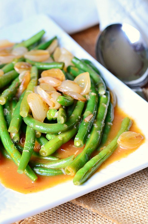 French Green Beans with onions on top on a white plate 