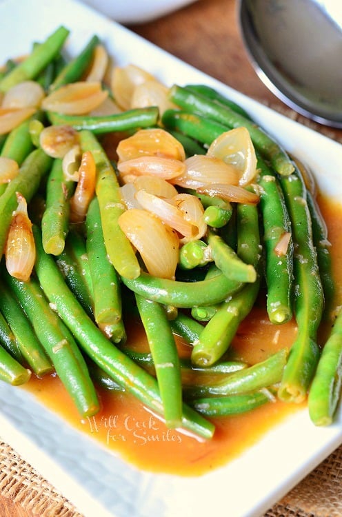 French Green Beans with onions on top on a white plate 