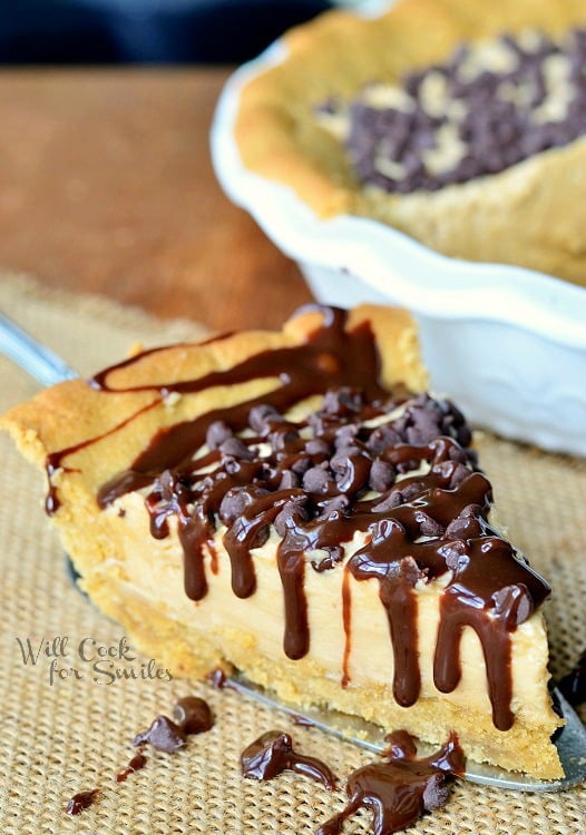 a slice of Peanut Butter Cheesecake Pie with chocolate chips and chocolate sauce on top 