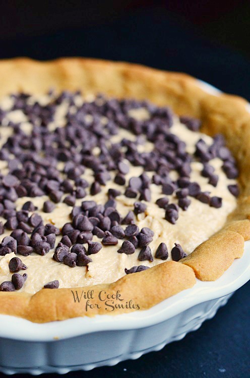 a slice of Peanut Butter Cheesecake Pie with chocolate chips and chocolate sauce on top 