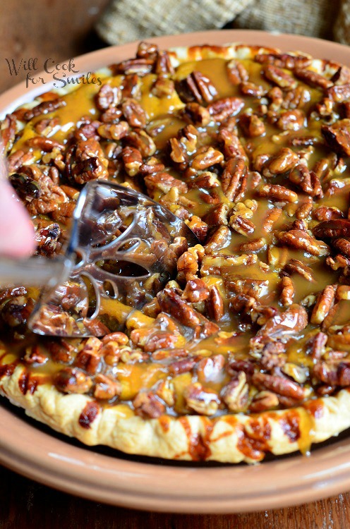 Pecan-Caramel Pumpkin Cheesecake Pie being sliced with a pie slicer 