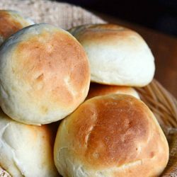 close up view of dinner rolls in basket with brown napkin