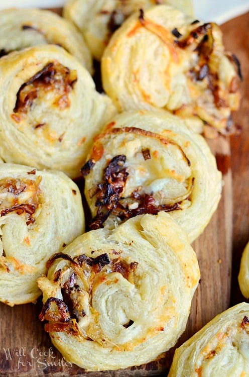 view from above of caramelized onion cheest pinwheels on a brown cutting board
