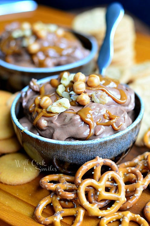 Chocolate Fruit Dip in a blue bowl with pretzels to the right 