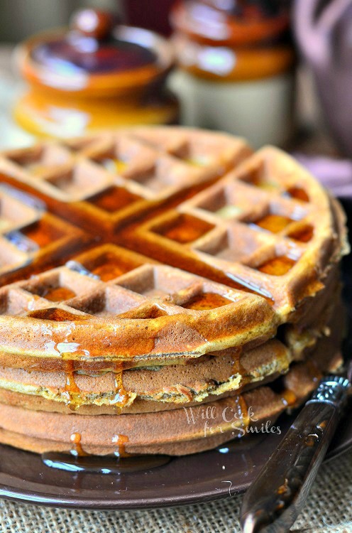 Gingerbread Waffles with syrup over the top on a brown plate 