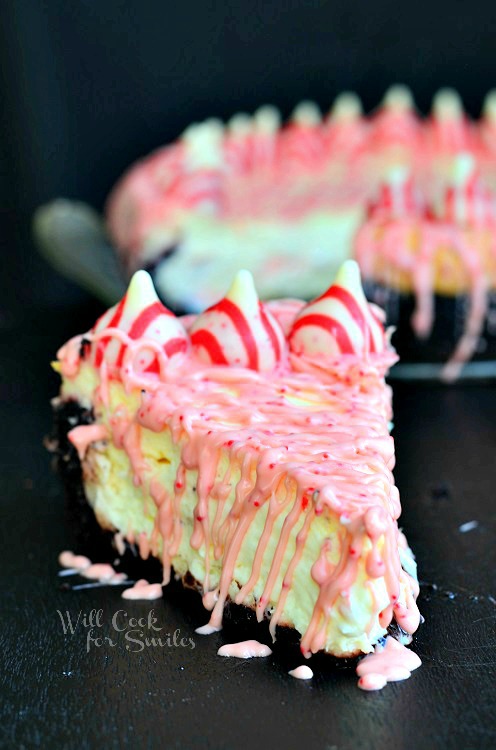 Peppermint Cheesecake with peppermint kisses along the outside and  with Oreo Cake Crust slice