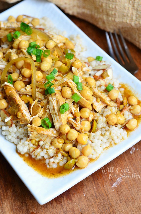 Moroccan Chicken on a white plate with chicken and chick peas and green onions slice on top 