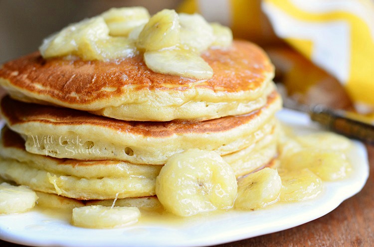 Bananas Foster Pancakes with sliced bananas on top on a white plate 