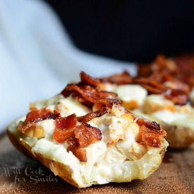 4 chicken bacon and ranch loaded potato skins lined up on a wood table