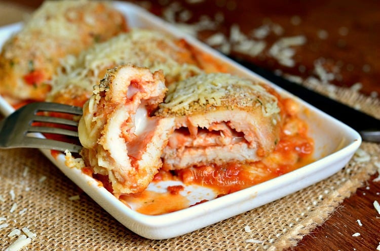 Chicken Parmesan Roll Up on a white plate with a fork with a bite on it 