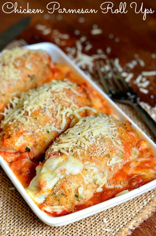 Chicken Parmesan Roll Ups in a white serving tray on a table with a fork to the right 