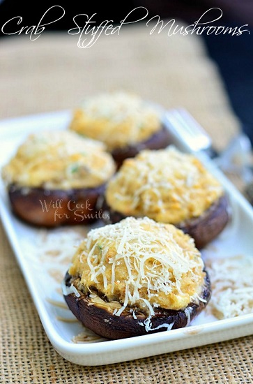 stuffed mushrooms on a white plate with grated cheese on top 