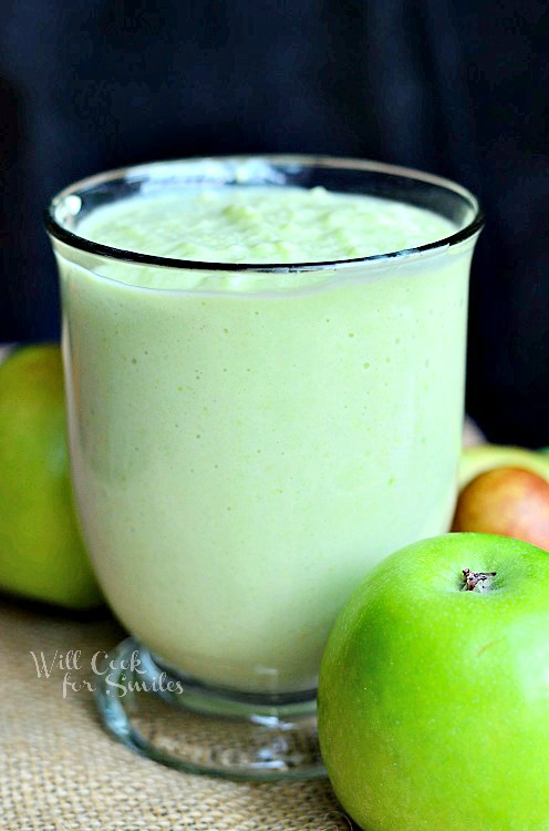 Green Apple Avocado Green Smoothie with apples next to the outside of the glass 