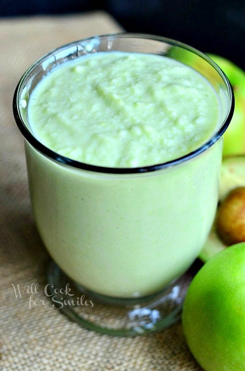 Green Apple Avocado Green Smoothie with apples next to the outside of the glass 