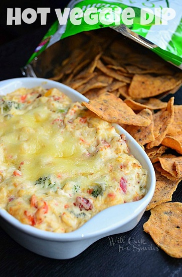 veggie dip in a white serving bowl with chips to the right 