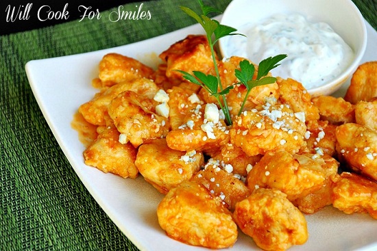 Buffalo Boneless Wings on a white plate with a bowl of blue cheese 