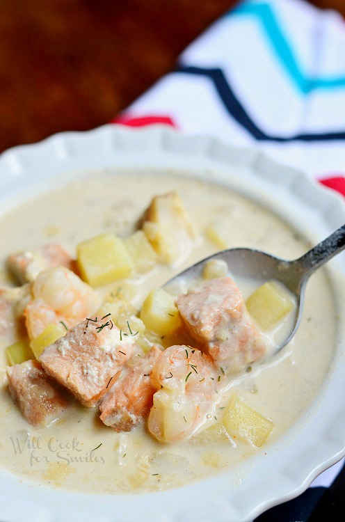 Seafood Chowder Soup in a white bowl with a spoon scooping some 