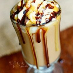 View from above of a chocolate caramel frozen coffee drink in a dessert glass on a wooden table