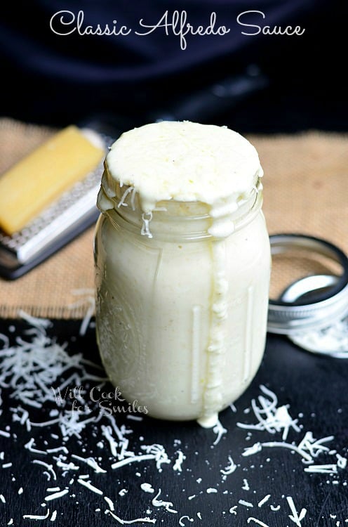  Alfredo Sauce in a jar with  parmesan cheese around it 
