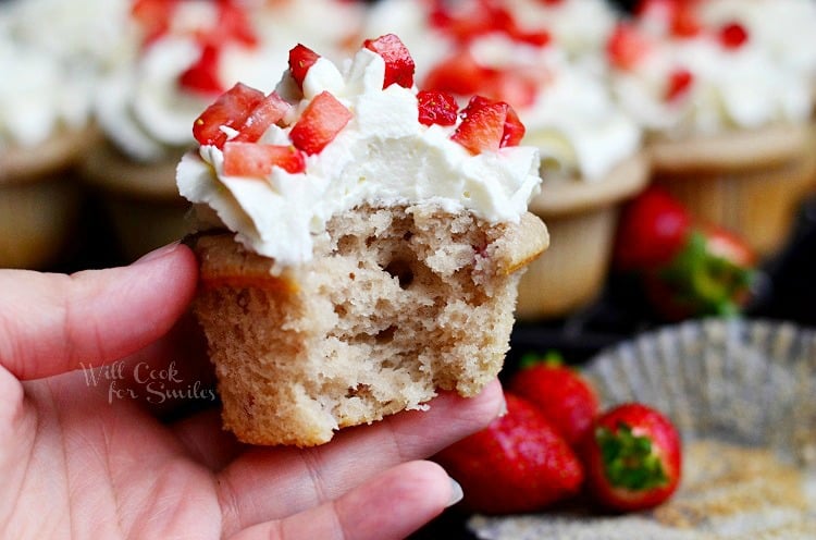 Strawberry Cupcakes with Mascarpone Frosting on a cooling rack with strawberries 