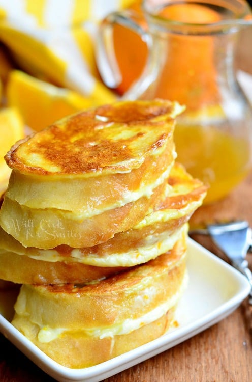 Orange Creamsicle French Toast stacked up on a white plate 