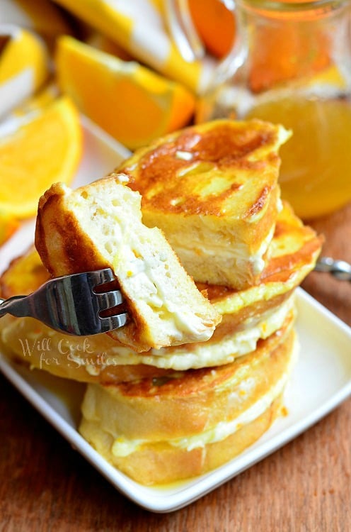 Orange Creamsicle French Toast sliced in half on a white plate 