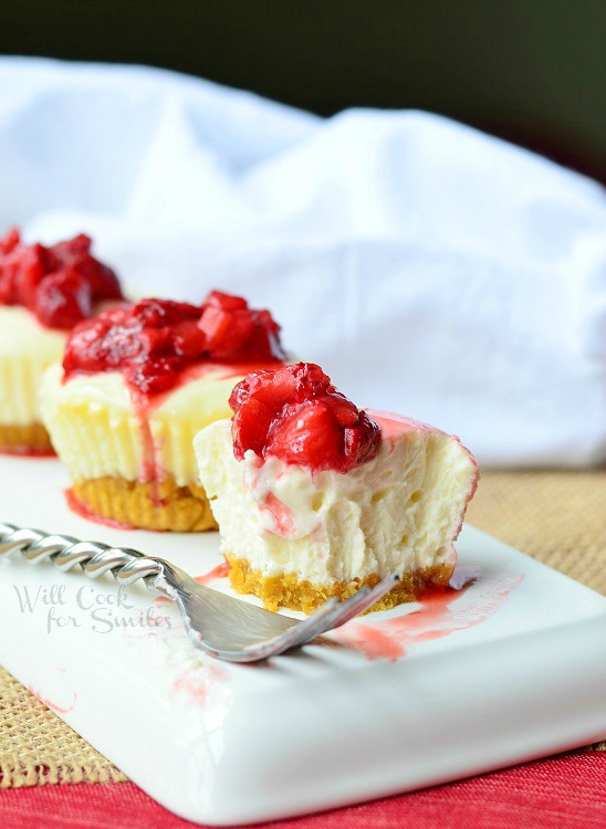 Skinny Mini Strawberry Cheesecakes on a white plate with a fork to the left