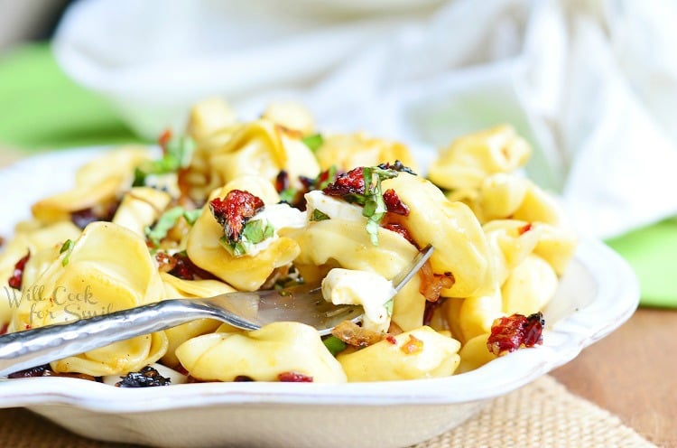 horizonal Caprese Tortellini in a bowl with a fork 