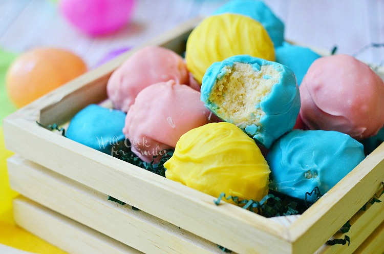 Easter Marshmallow Oreo Truffles in a wood box with a bite out of one of one 