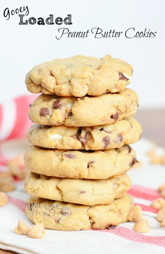 Peanut Butter Cookies with chocolate chips and peanut chips stacked on a tea towel 