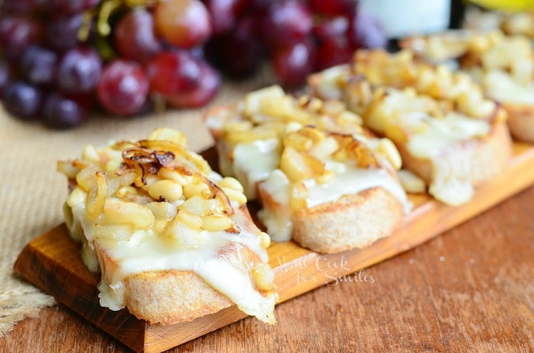 President's Cheese Crostini wtih Brie Caramelized Onion Pear and Pine Nuts on a tray 