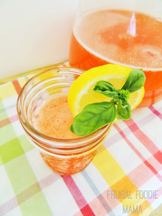 strawberry basil lemonade in a glass with lemons and basil 