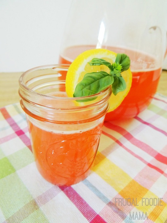 strawberry lemonade in a mason jar with lemon and basil on the rim 