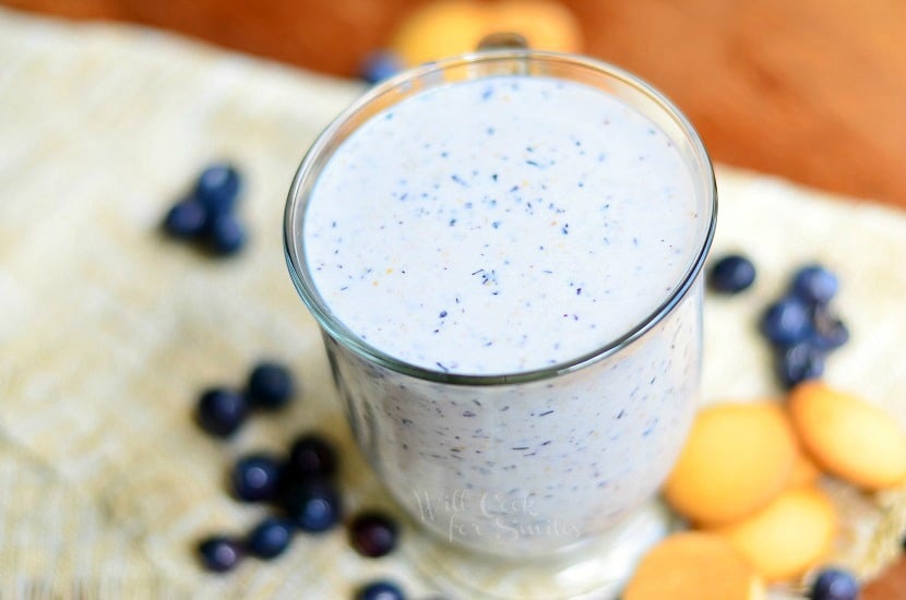 Blueberry Muffin Milkshake in a glass cup with blueberries around it 