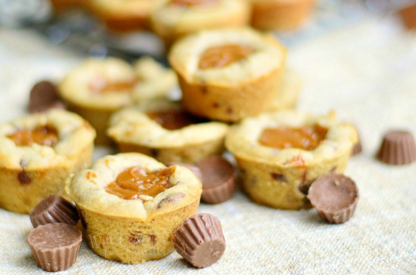 Dulce De Leche Peanut Butter Cup Cookies on a tan placemat with mini reese candy around it 