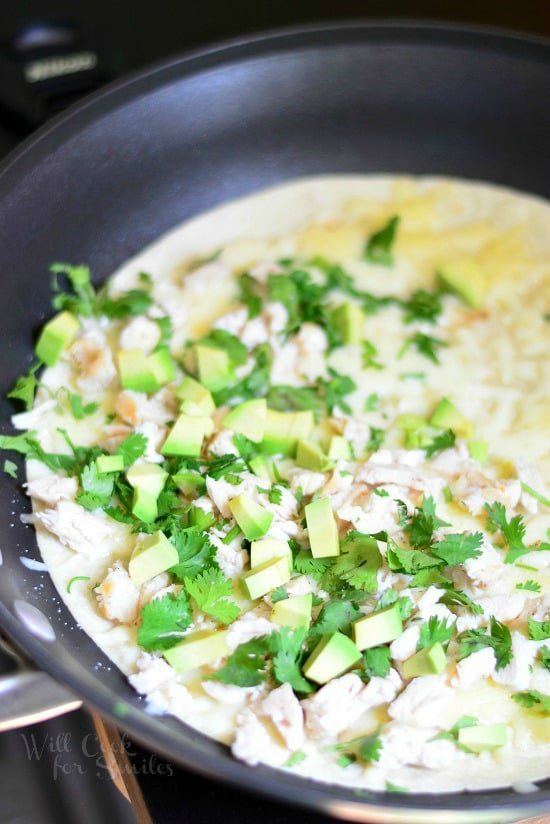 Avocado Chicken on top of a tortilla in a frying pan to make a  Quesadilla 