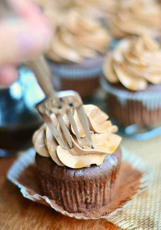 Bourbon Chocolate Cupcakes on a wood cutting board with a fork in the middle 